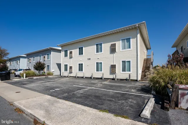 a view of a white house with a yard