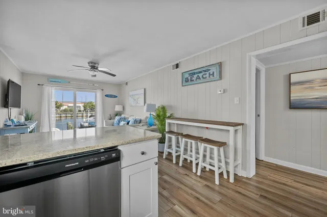 a kitchen with granite countertop a stove a sink and a wooden cabinets