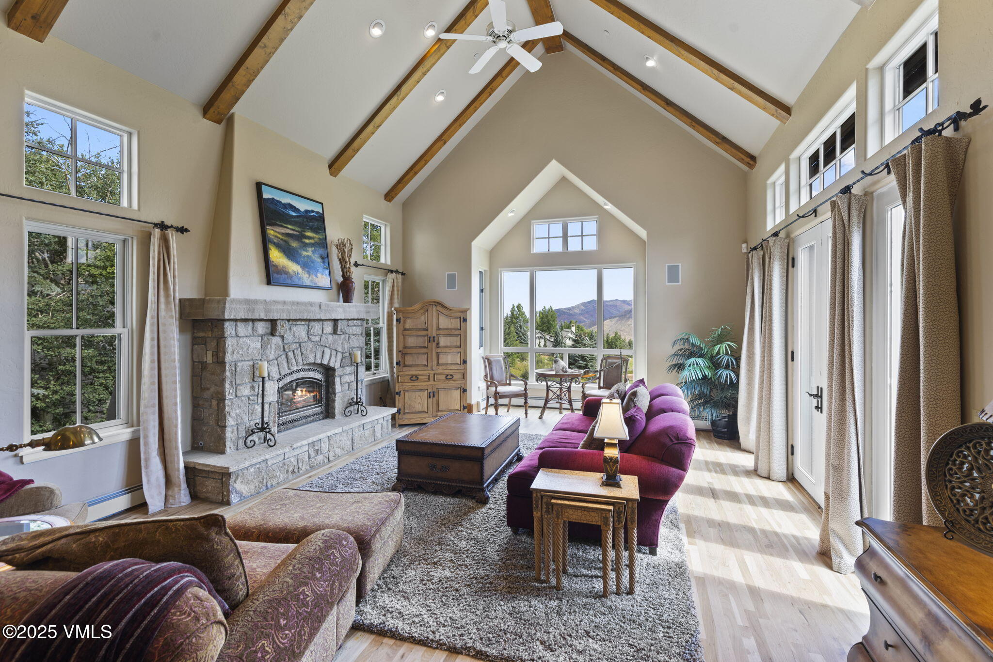 a living room with furniture a large window and a fireplace