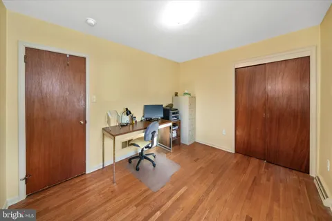 a view of a workspace with wooden floor and a bathroom