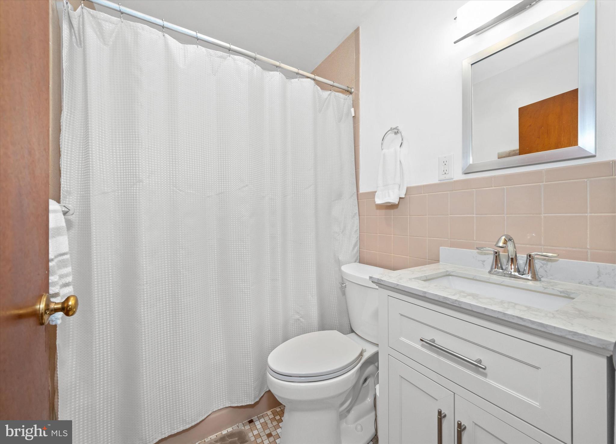 213 Valley Lane Hockessin, DE 19707 - Photo 22 of 27 a bathroom with a sink a toilet and shower curtain