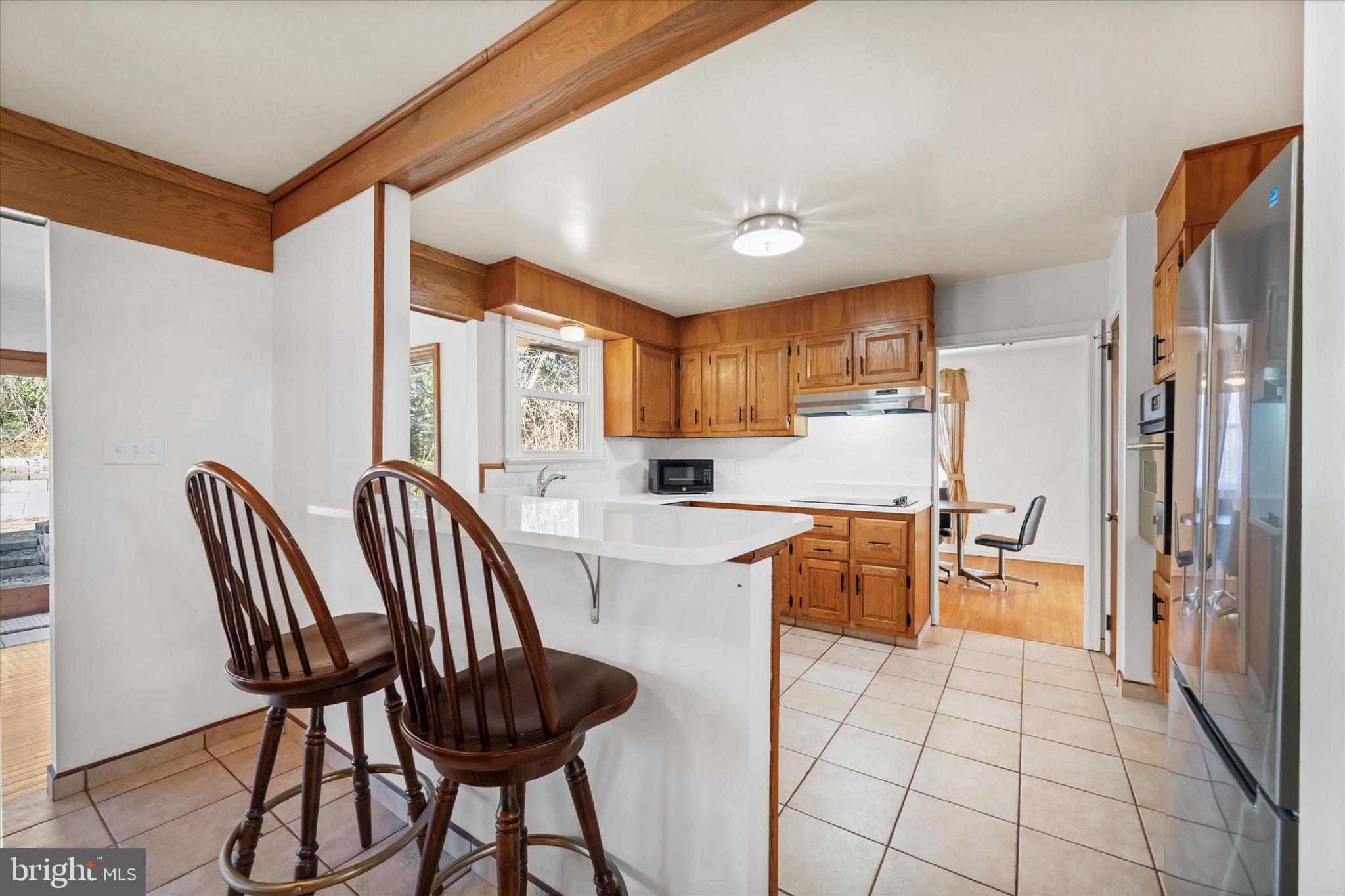 213 Valley Lane Hockessin, DE 19707 - Photo 7 of 27 a kitchen with a table chairs refrigerator and cabinets