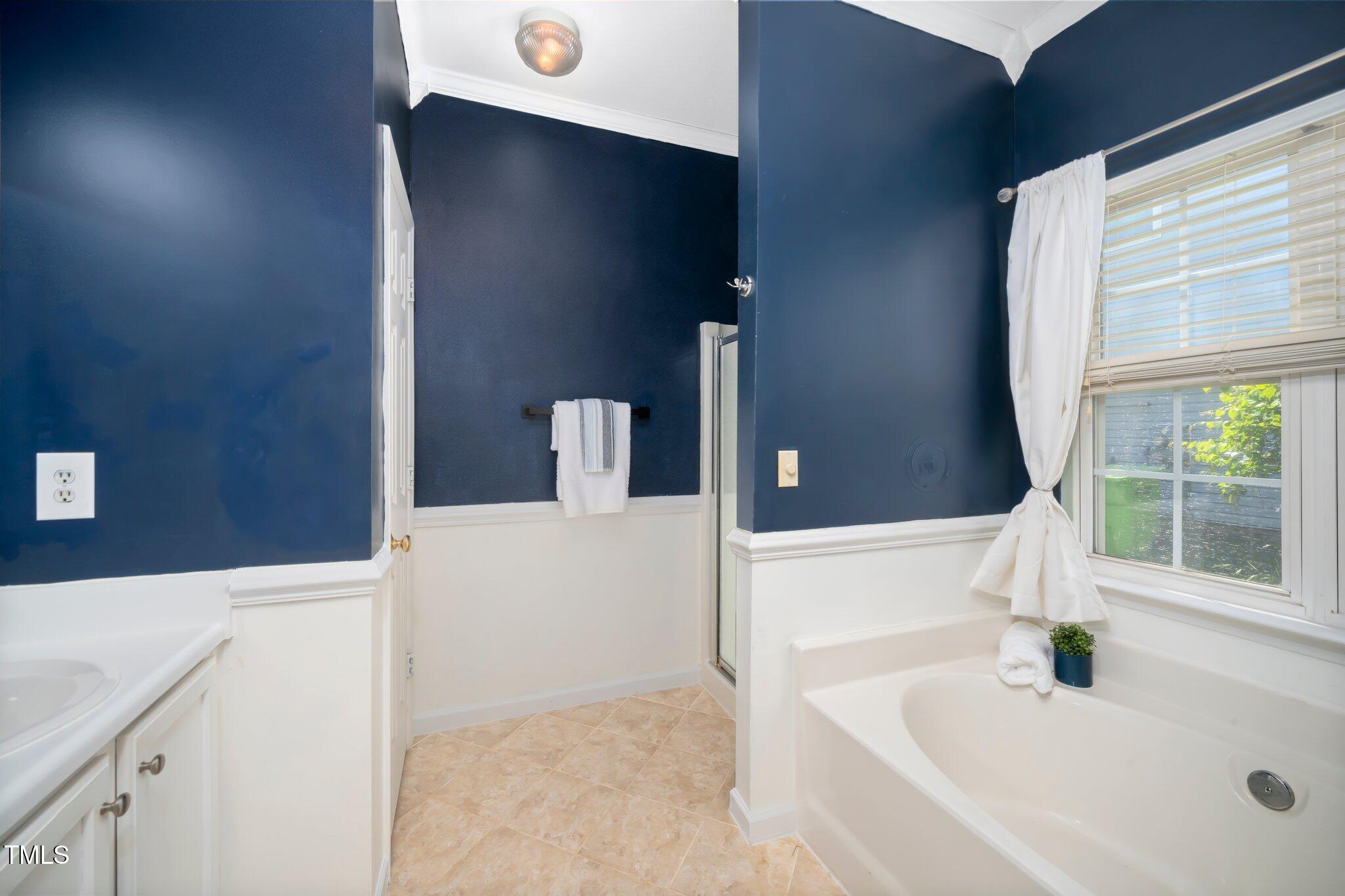 8300 Neuse Hunter Drive Raleigh, NC 27616 - Photo 18 of 32 a bathroom with a tub a sink and a large window