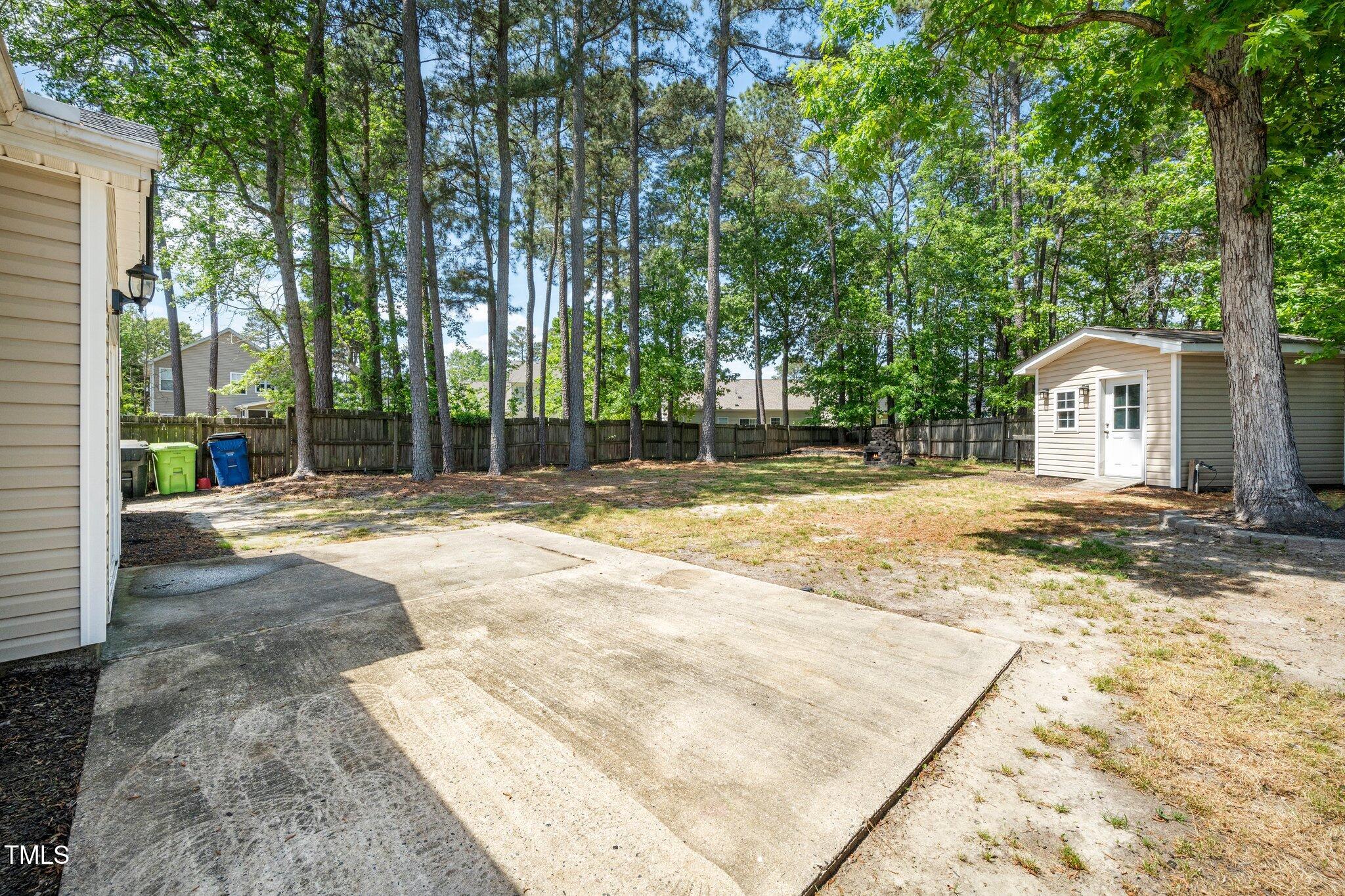 8300 Neuse Hunter Drive Raleigh, NC 27616 - Photo 23 of 32 a backyard of a house with large trees and outdoor seating