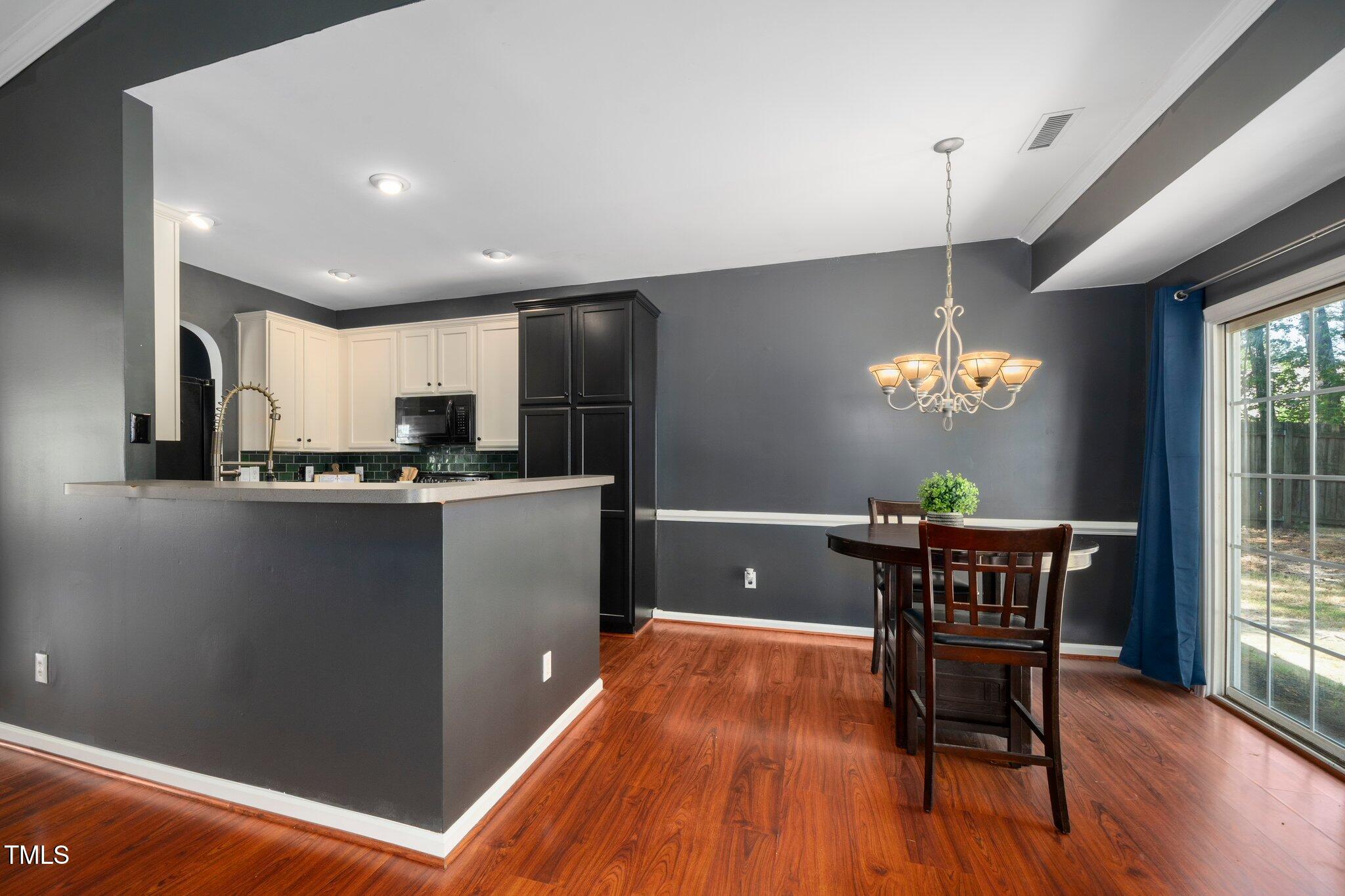 8300 Neuse Hunter Drive Raleigh, NC 27616 - Photo 10 of 32 a kitchen with stainless steel appliances granite countertop a refrigerator a sink a stove a dining table and chairs