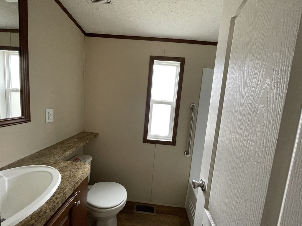 268 Palmer Road, Unit 23 Monson, MA 01057 - Photo 16 of 18 a white toilet sitting next to a bathroom sink