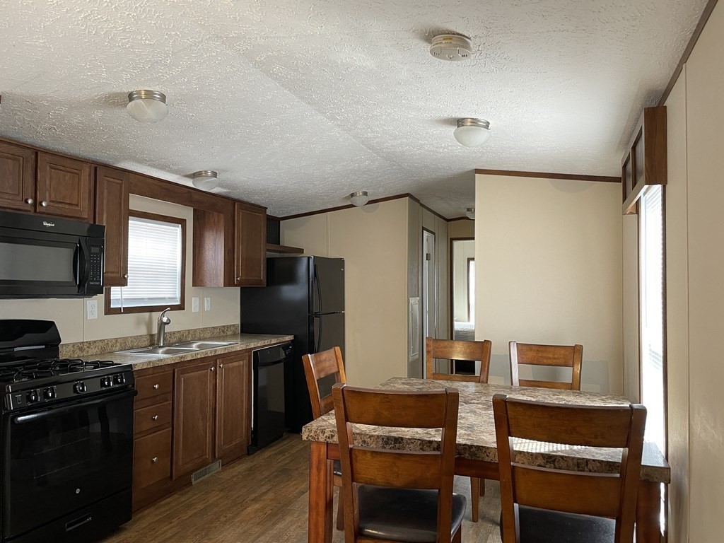 268 Palmer Road, Unit 23 Monson, MA 01057 - Photo 5 of 18 a kitchen with stainless steel appliances granite countertop a stove refrigerator sink and cabinets