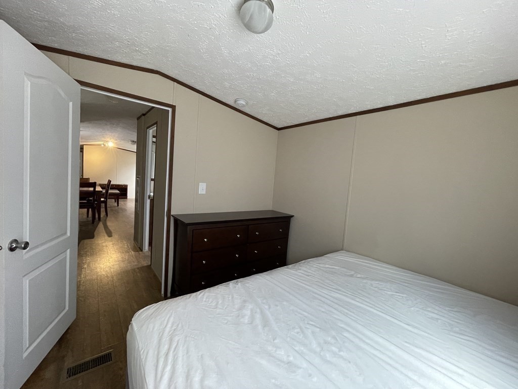 268 Palmer Road, Unit 23 Monson, MA 01057 - Photo 8 of 18 a bedroom with a bed and a table in it