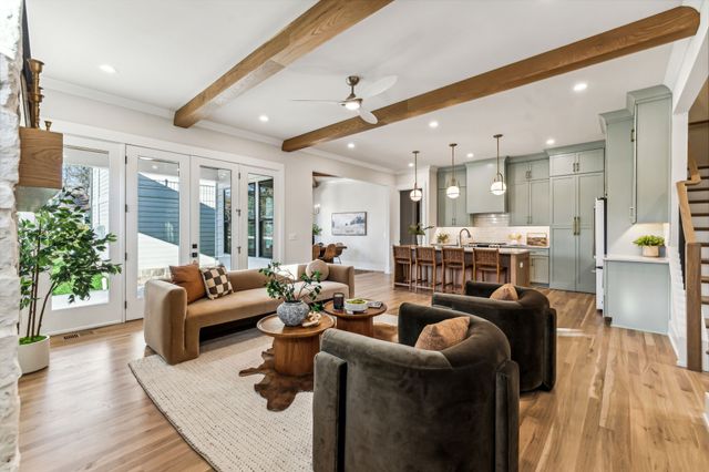 a kitchen with stainless steel appliances kitchen island granite countertop a dining table chairs and white cabinets