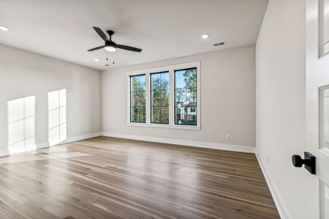 a view of kitchen with kitchen island a sink wooden floor and a large window