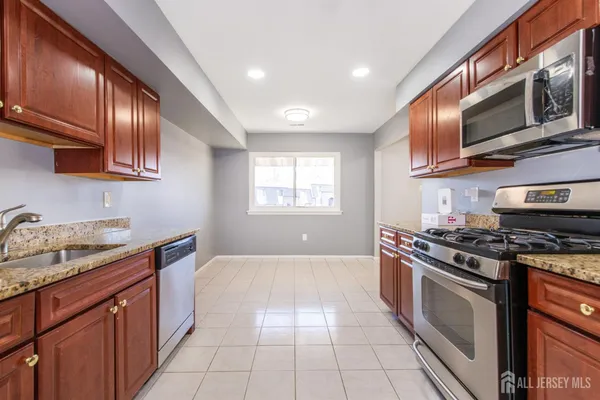 a kitchen with stainless steel appliances granite countertop a stove a sink and a refrigerator