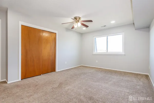 an empty room with closet and a chandelier fan