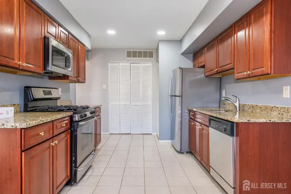 a kitchen with stainless steel appliances granite countertop a stove a sink and a refrigerator