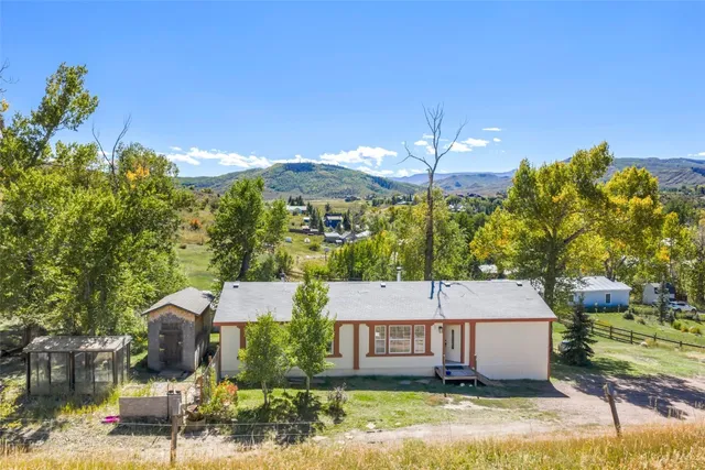 a view of a white house next to a yard
