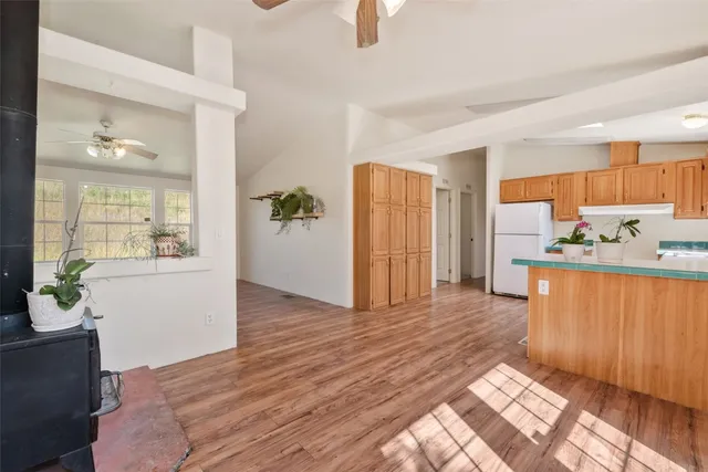 a view of a kitchen with wooden floor and a refrigerator