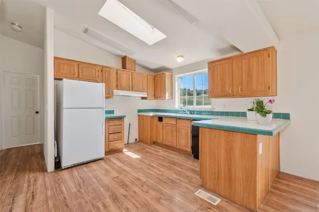 a kitchen with wooden floors and refrigerator