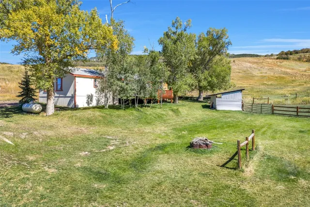 a backyard of a house with barbeque oven table and chairs