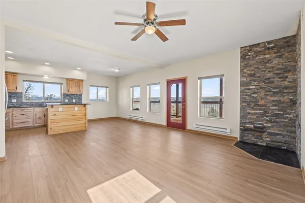 a view of an empty room with a window and wooden floor