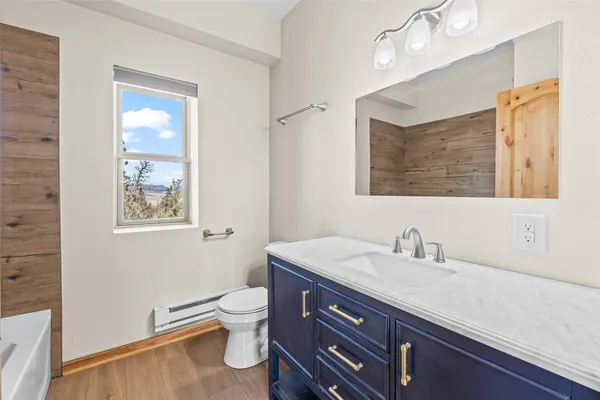 a bathroom with a sink a toilet and a mirror