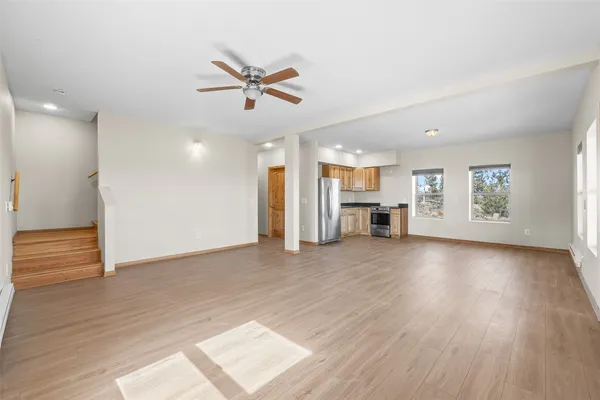 a view of empty room with wooden floor and window