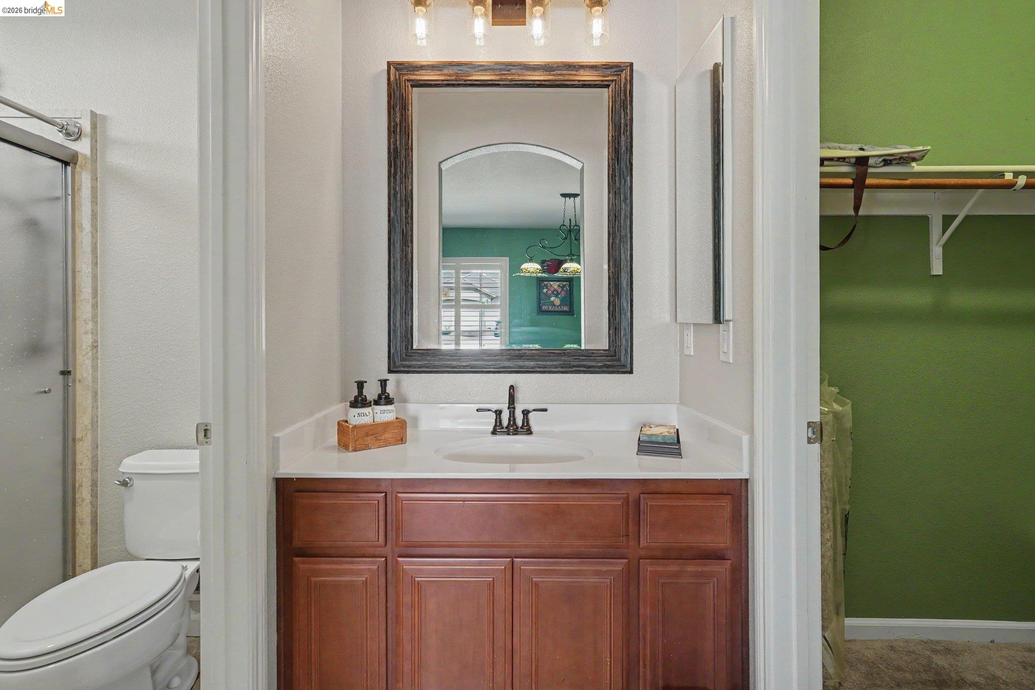 106 Little Ranch Circle Oakley, CA 94561 - Photo 9 of 34 Bathroom vanity featuring a wood-finish cabinet, white countertop with an integrated sink, and an oil-rubbed bronze faucet