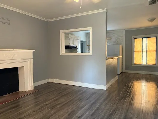 a view of empty room with wooden floor and fireplace