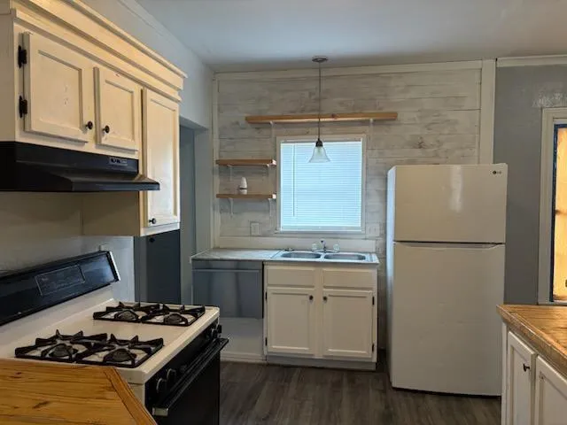 a kitchen with a stove a refrigerator and a cabinets