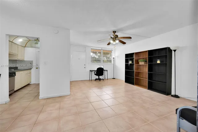 a view of empty room with cabinet and ceiling fan