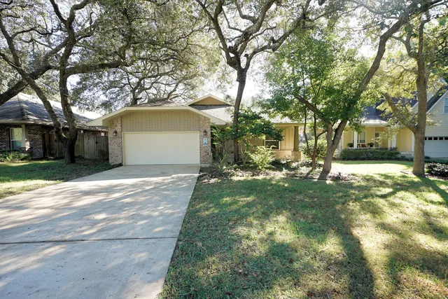 a view of a yard with a house and a large tree