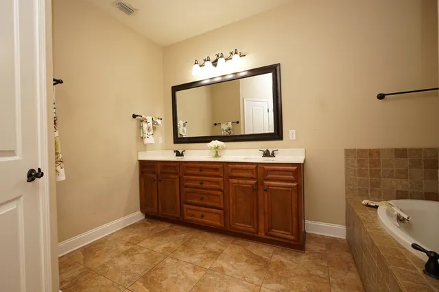 a bathroom with a tub sink and mirror