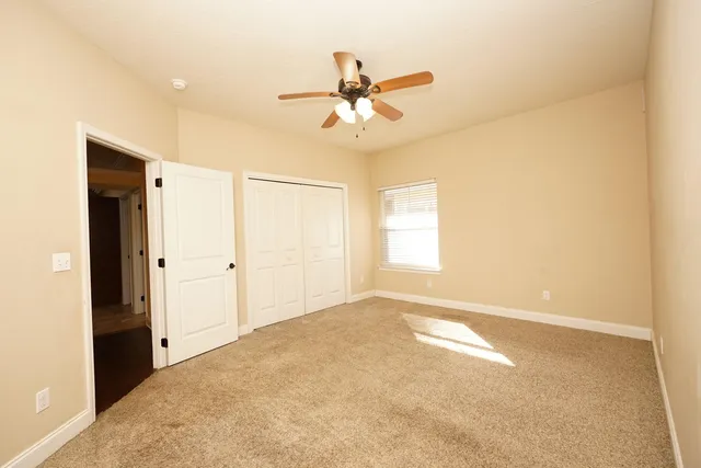 a view of a livingroom with a ceiling fan & window