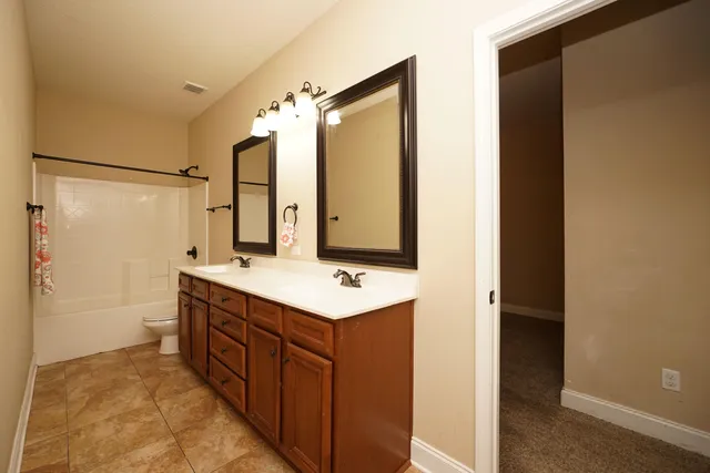 a bathroom with a double vanity sink mirror and shower