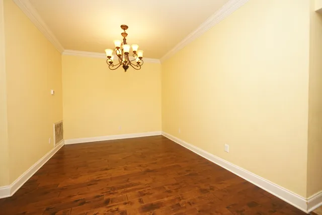 a view of a room with wooden floor and chandelier