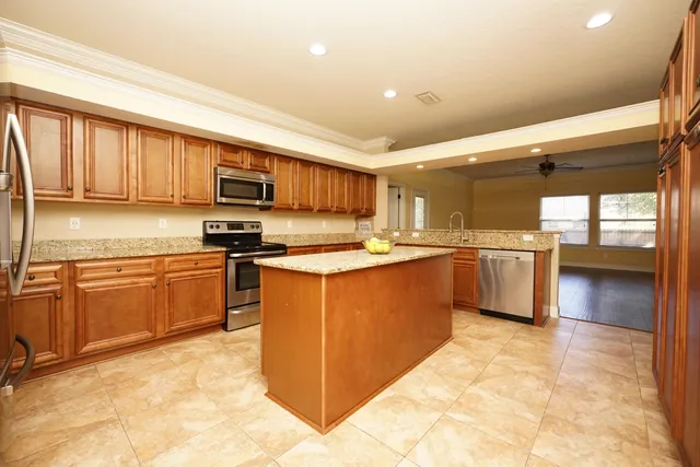 a kitchen with stainless steel appliances granite countertop a stove top oven a sink a counter top space and cabinets
