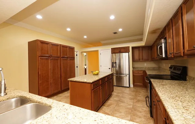 a kitchen with stainless steel appliances granite countertop a sink refrigerator and cabinets