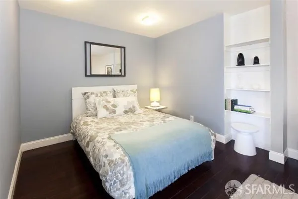 a bedroom with a bed and painting on the wall