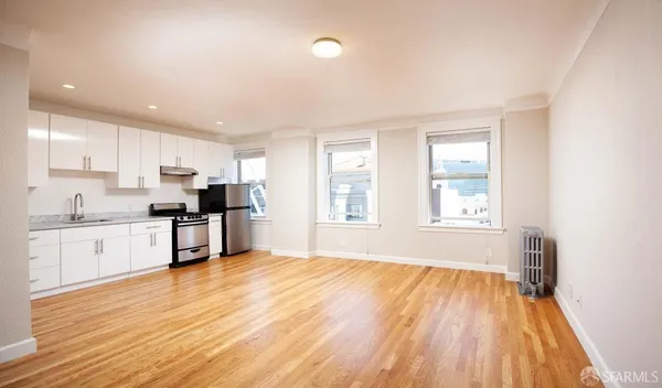 a open kitchen with granite countertop white cabinets and wooden floor