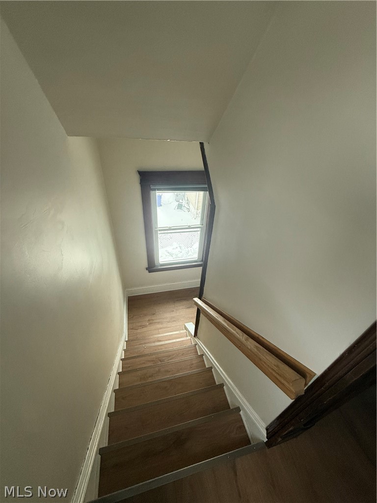 3612 Riverside Avenue Cleveland, OH 44109 - Photo 2 of 22 Staircase with wood-finish treads and risers, featuring a natural wood handrail and a window with dark trim