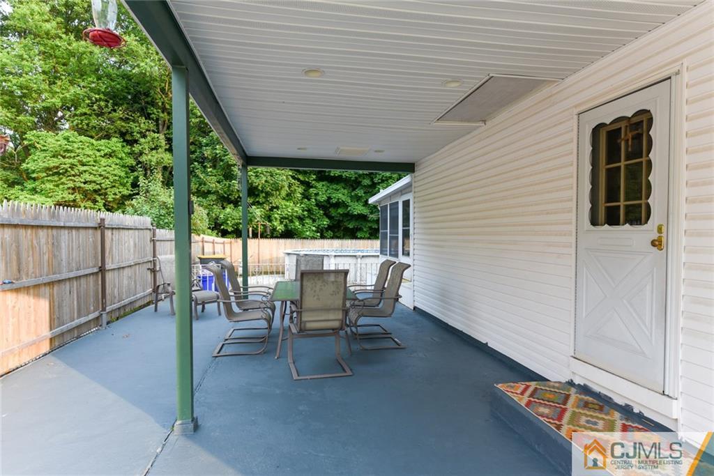 178 Princeton Road Old Bridge, NJ 08859 - Photo 14 of 16 a view of a patio with table and chairs and wooden fence