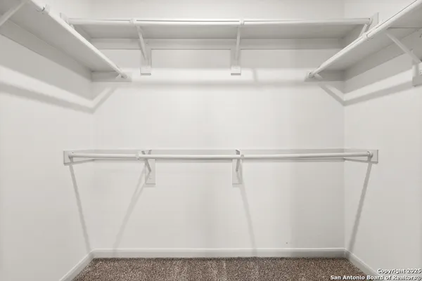 a view of walk in closet with empty racks