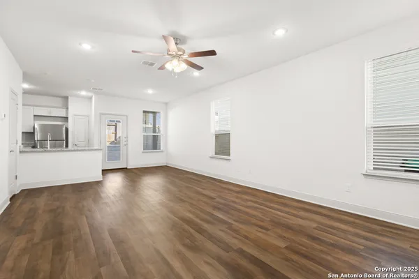 a view of an empty room with window and wooden floor