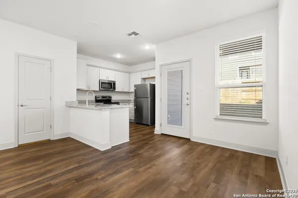 a kitchen with granite countertop a refrigerator and a stove top oven