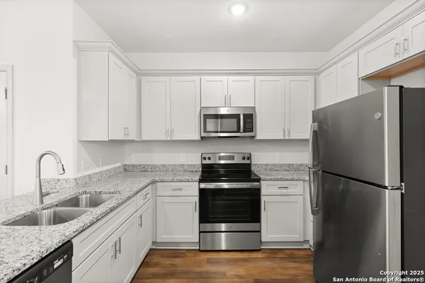 a kitchen with stainless steel appliances granite countertop a refrigerator sink and stove