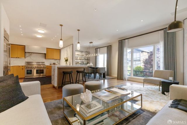 a kitchen with kitchen island granite countertop a table chairs stove a refrigerator and cabinets