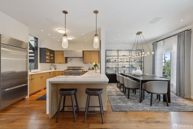 a kitchen with kitchen island a refrigerator a sink and wooden cabinets