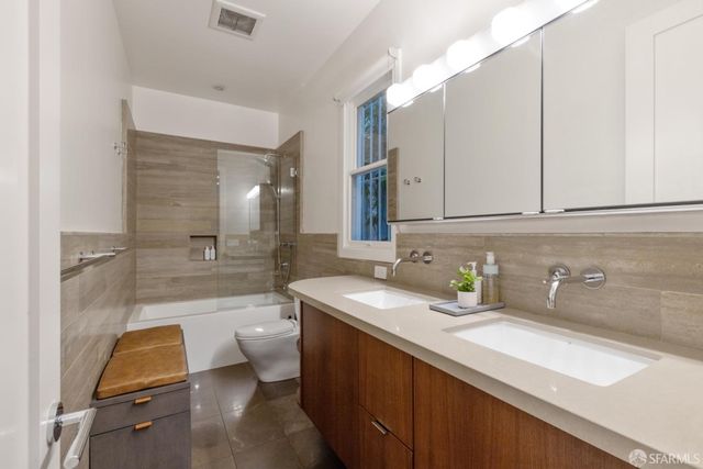 a bathroom with a double vanity sink a mirror and a shower