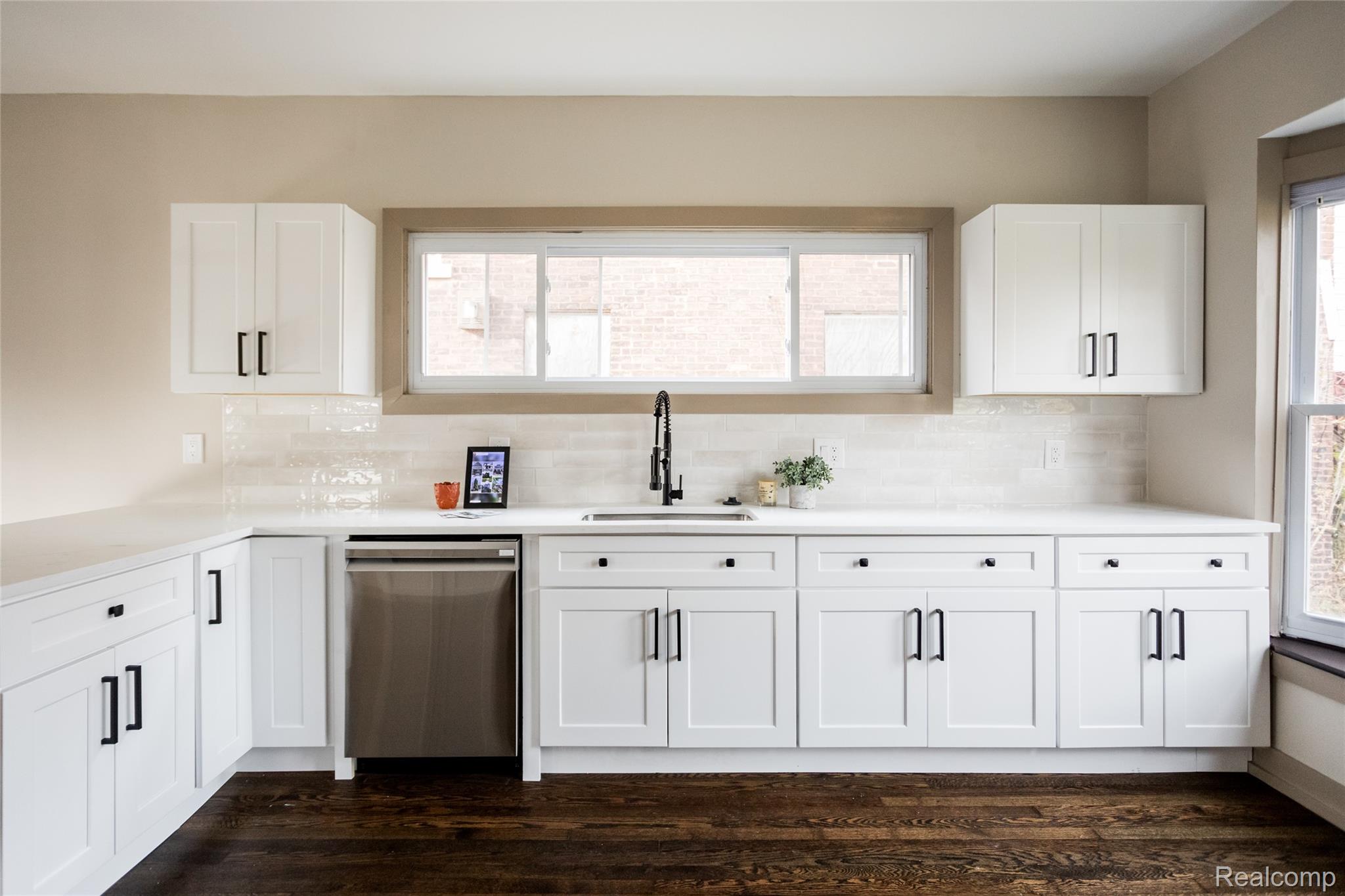 2630 Harding Street Detroit, MI 48214 - Photo 9 of 30 Kitchen featuring white shaker cabinetry with black hardware, white countertops, and a subway tile backsplash