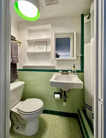 a bathroom with a sink toilet and mirror