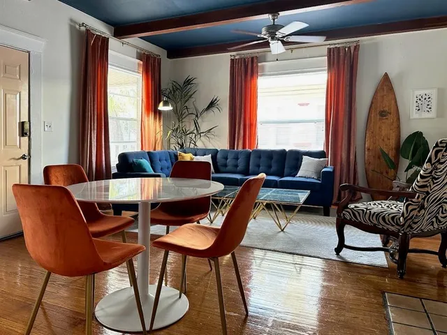 a dining room with furniture a chandelier and wooden floor