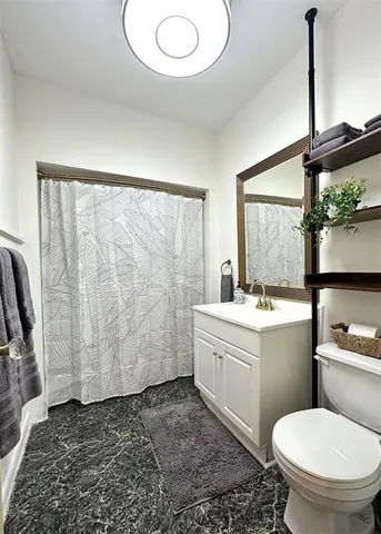 a bathroom with a granite countertop sink toilet and shower